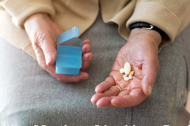elderly hand holding pills